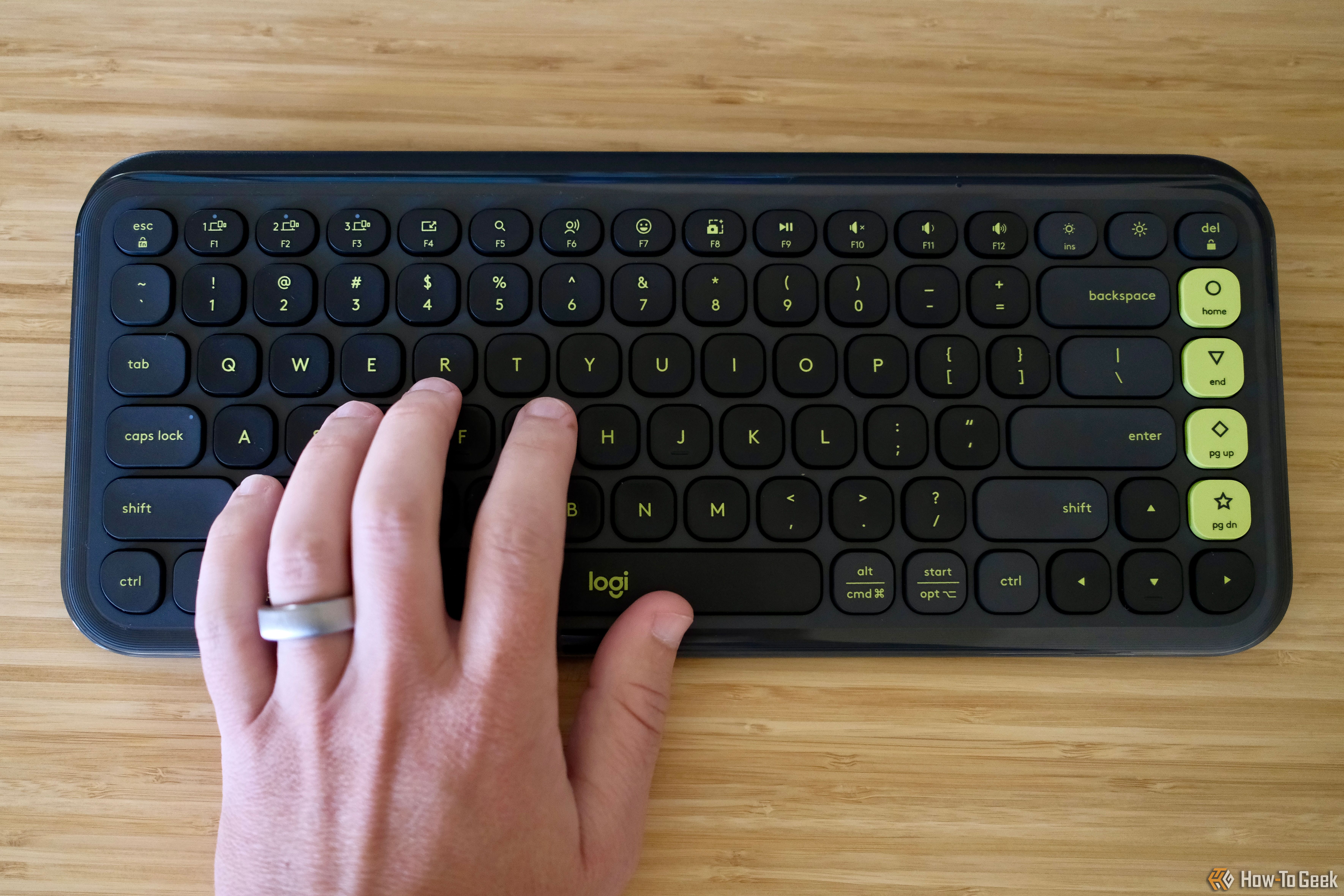 Logitech Pop Icon Keys on a desk with a hand typing on it.