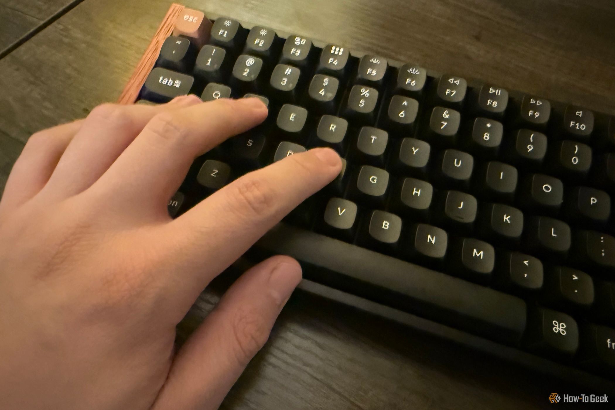 A hand typing on the Keychron K2 HE Special Edition black keyboard.