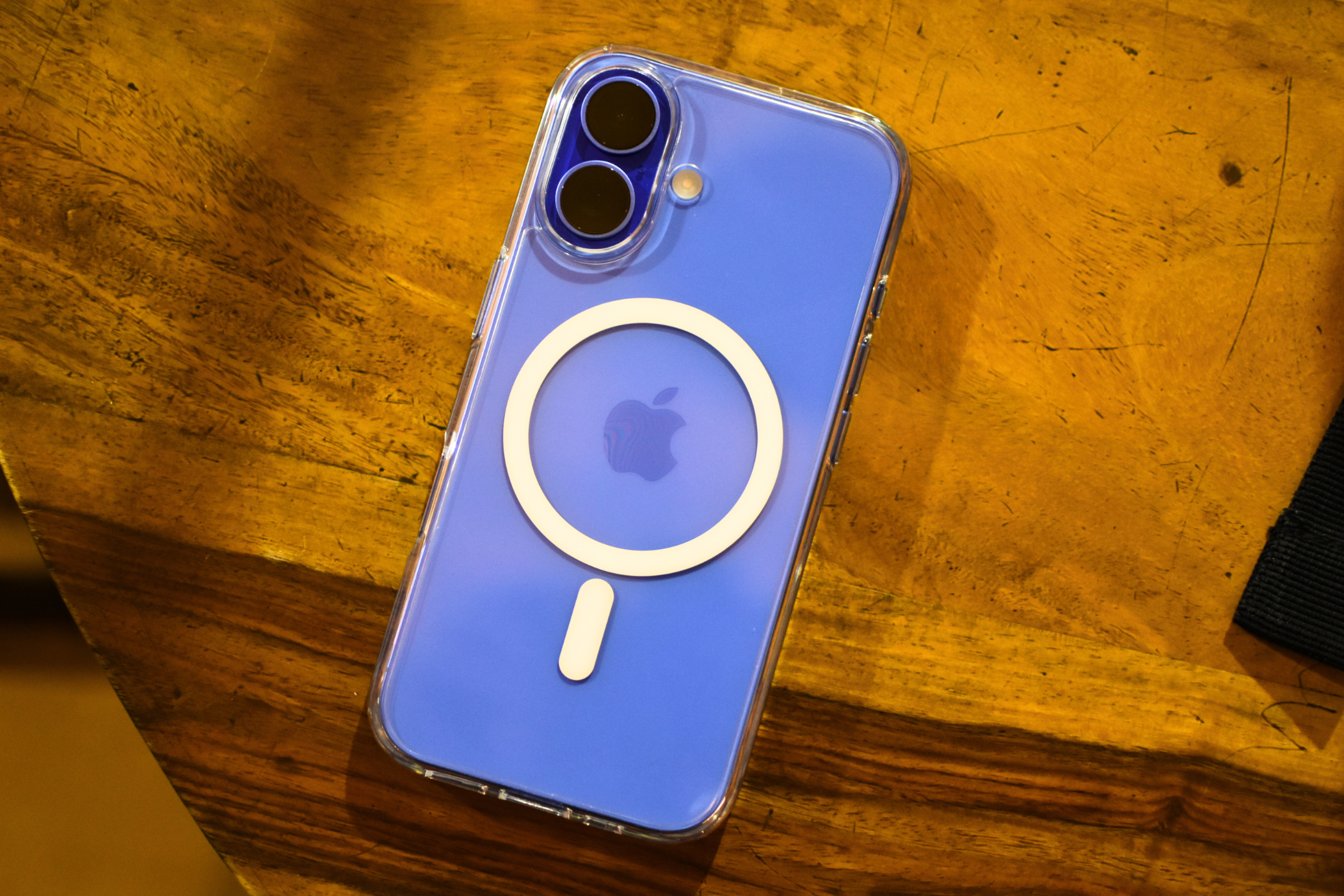 iPhone 16 in Ultramarine color with a transparent MagSafe case slapped on its back.