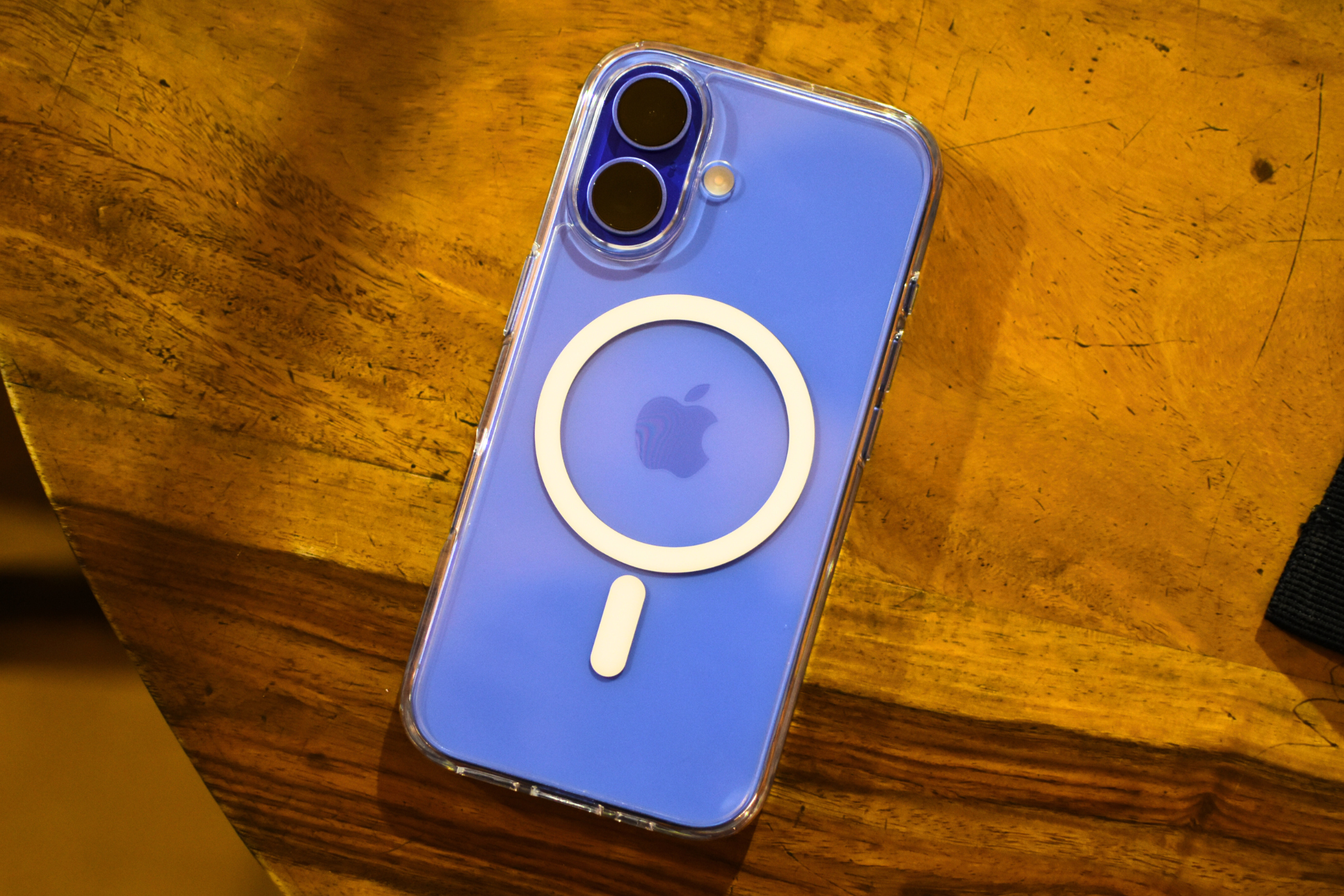 iPhone 16 in Ultramarine color with a transparent MagSafe case slapped on its back.