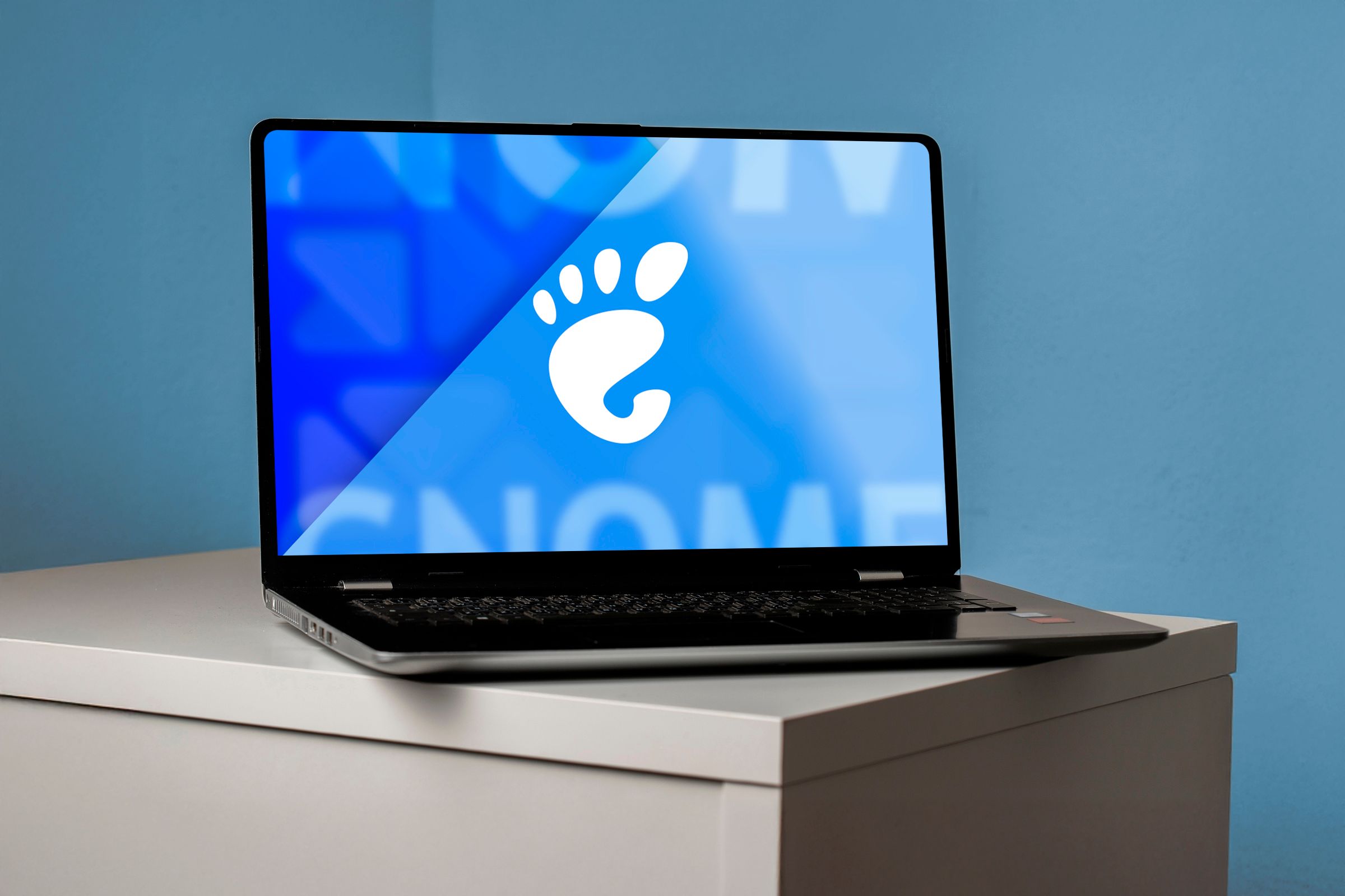 A laptop with the GNOME logo on the screen.