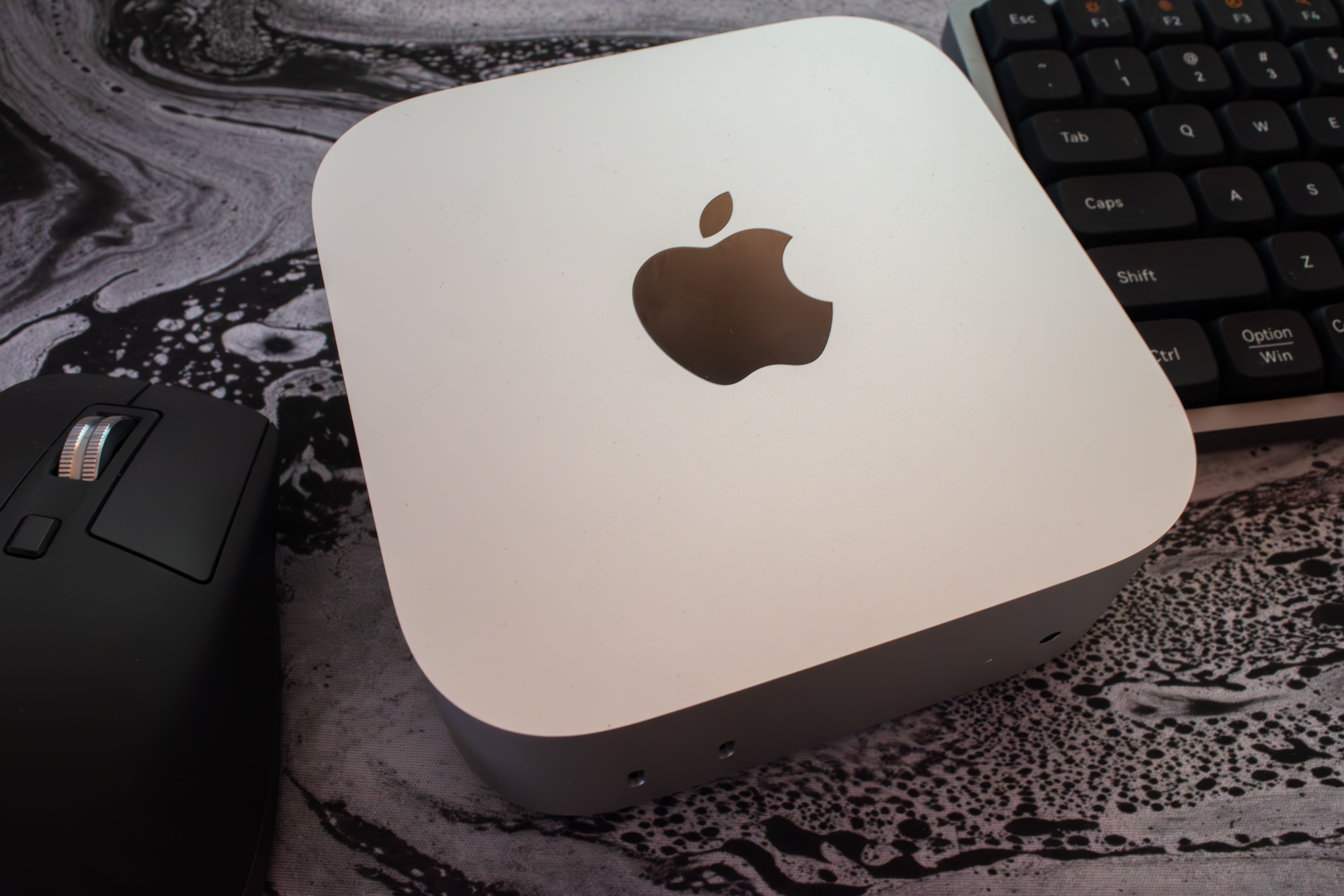 An M4 Mac Mini surrounded by a keyboard and a mouse.