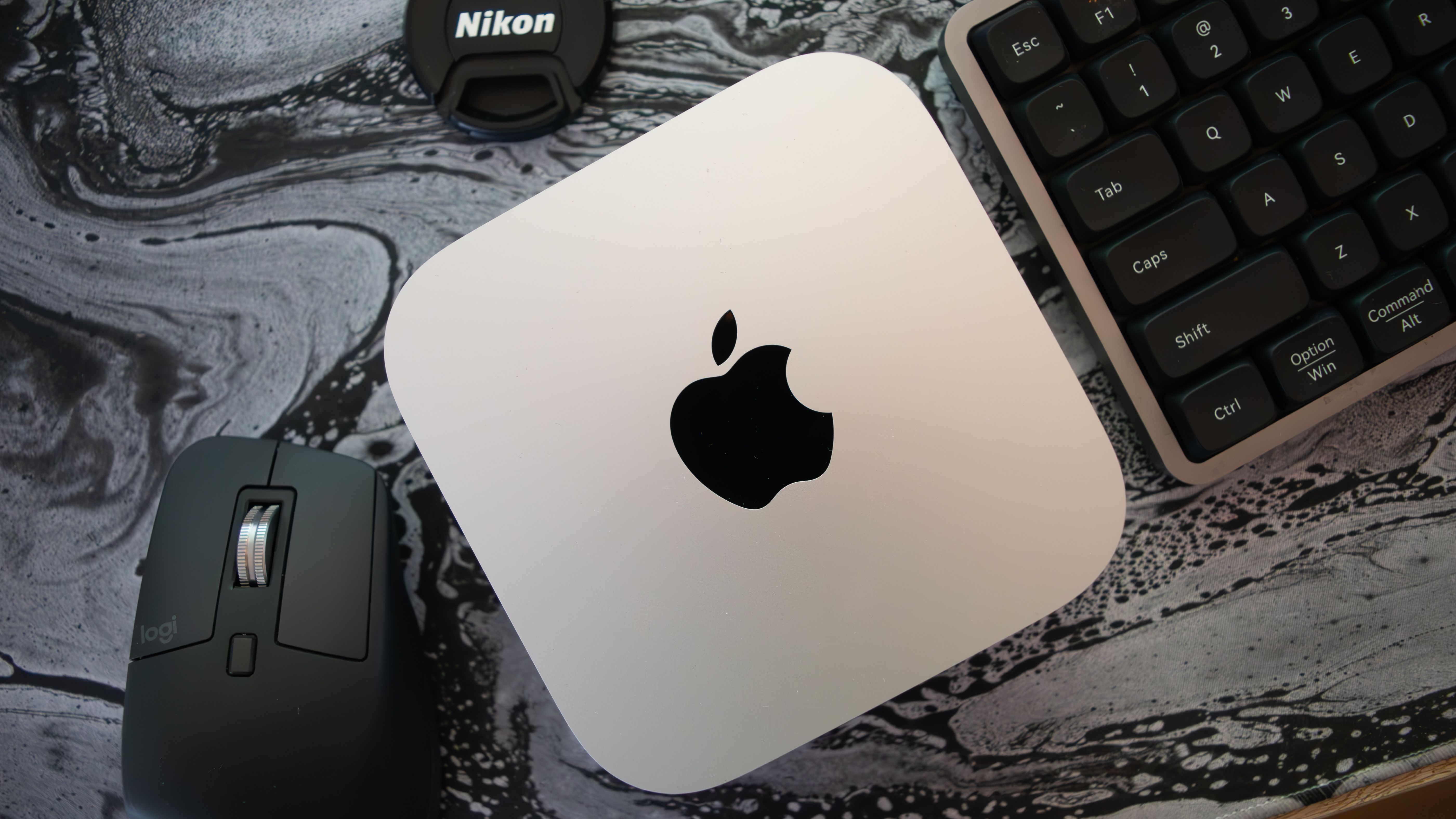 An M4 Mac Mini surrounded by a keyboard and a mouse.