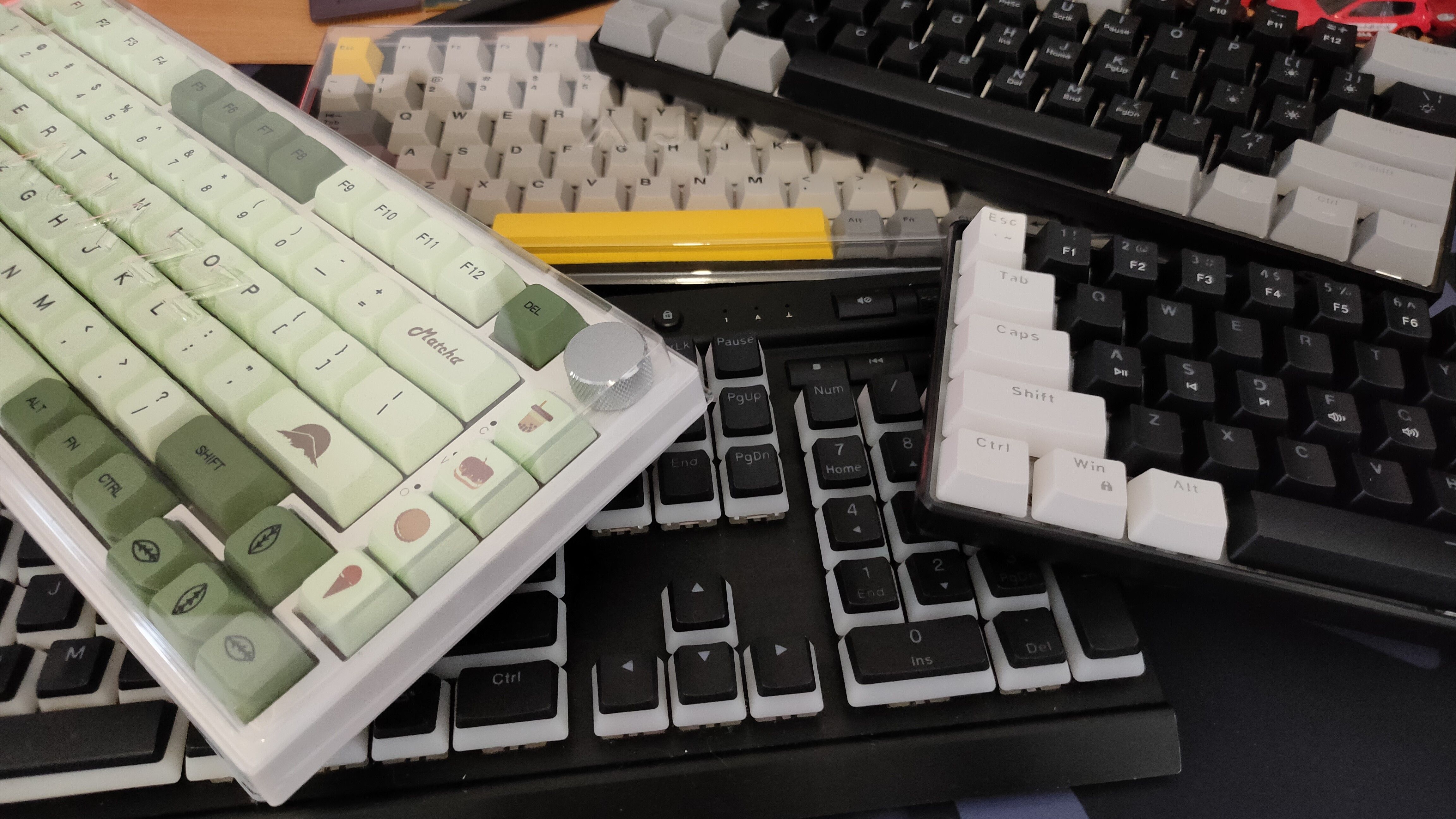 Five mechanical keyboards on a desk.