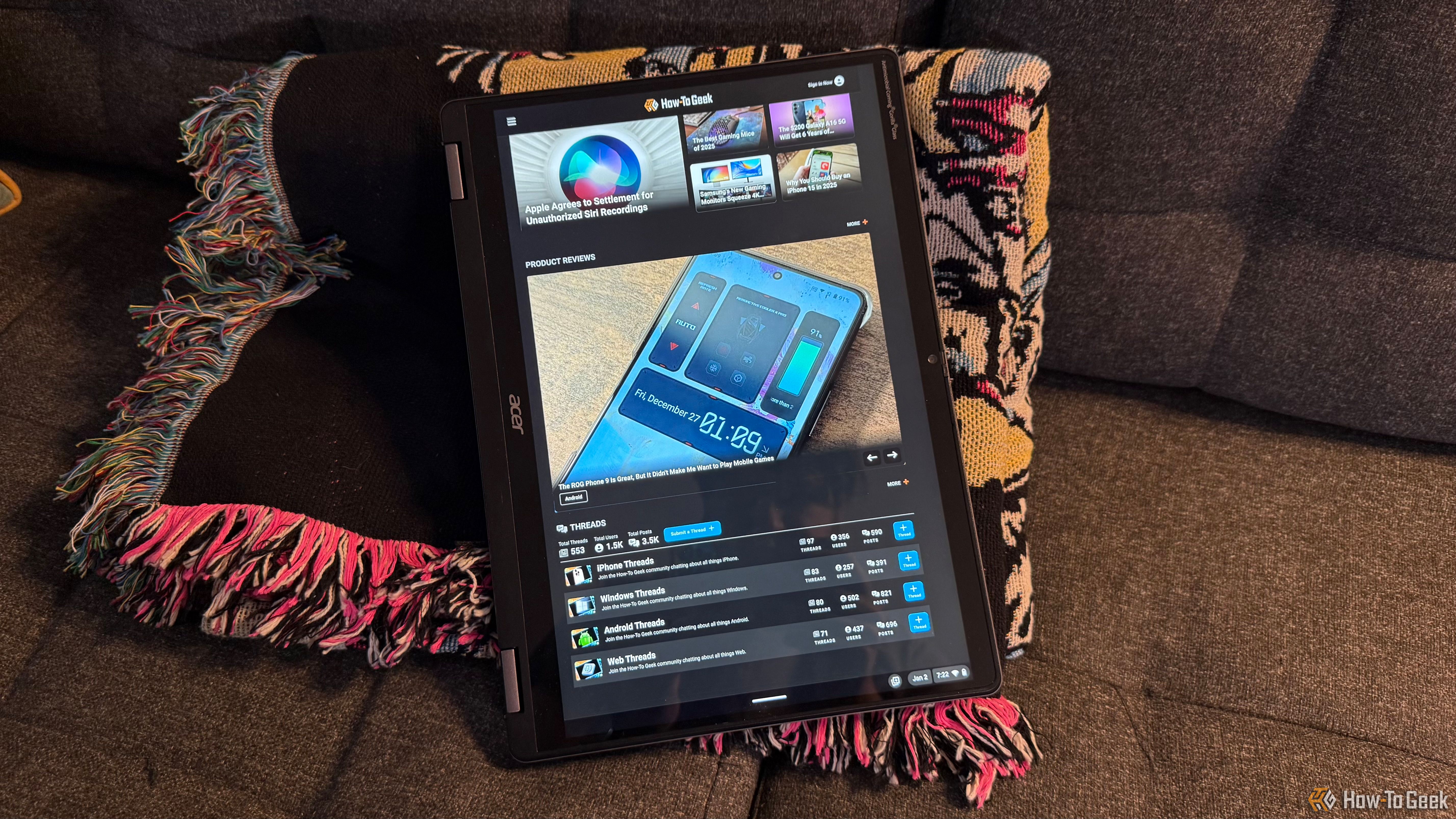 The Acer Chromebook Plus Spin 514 in tablet mode resting on a blanket on a couch.