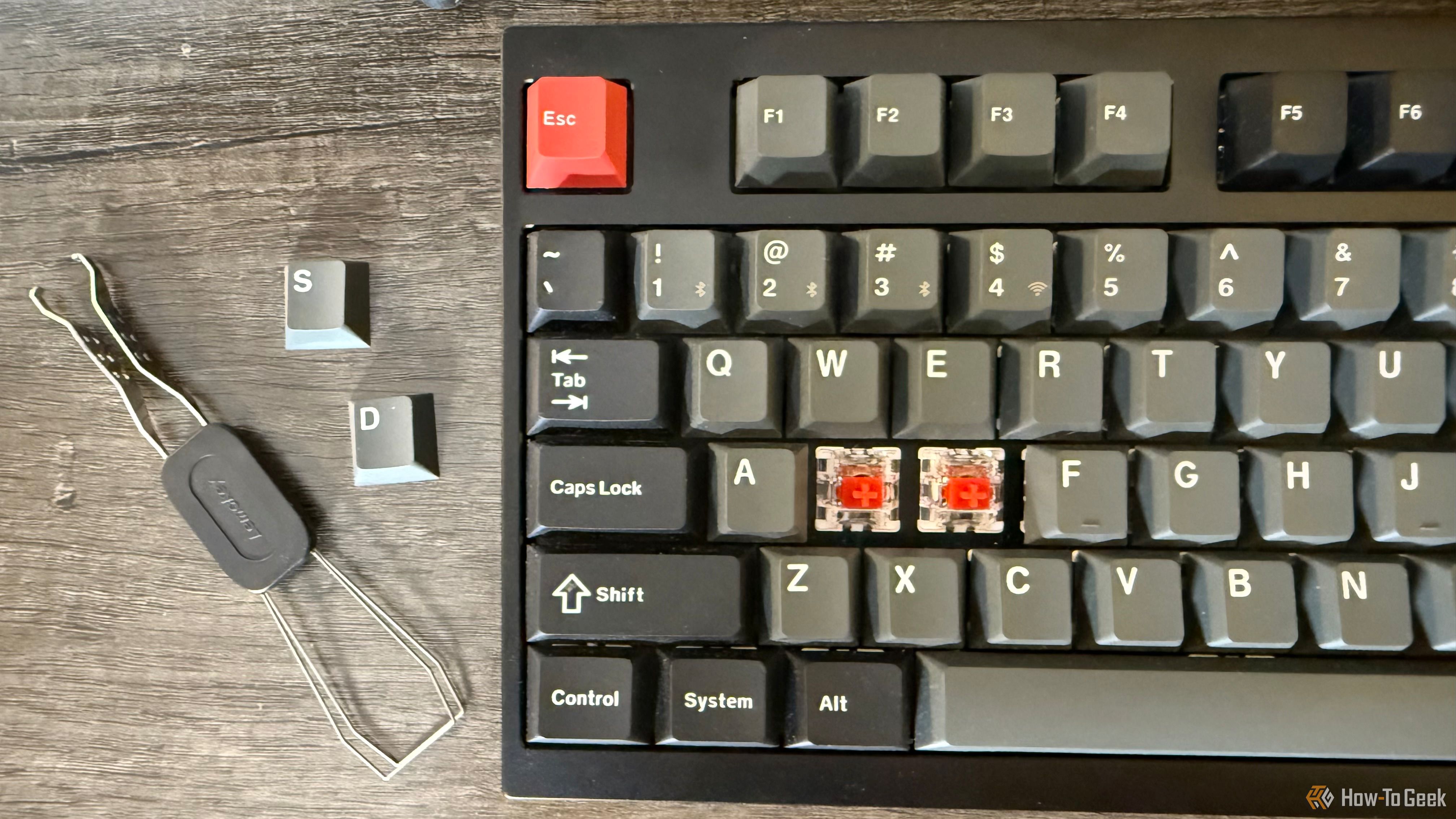 Keychron Lemokey L4 with keycaps pulled off and red switches exposed.