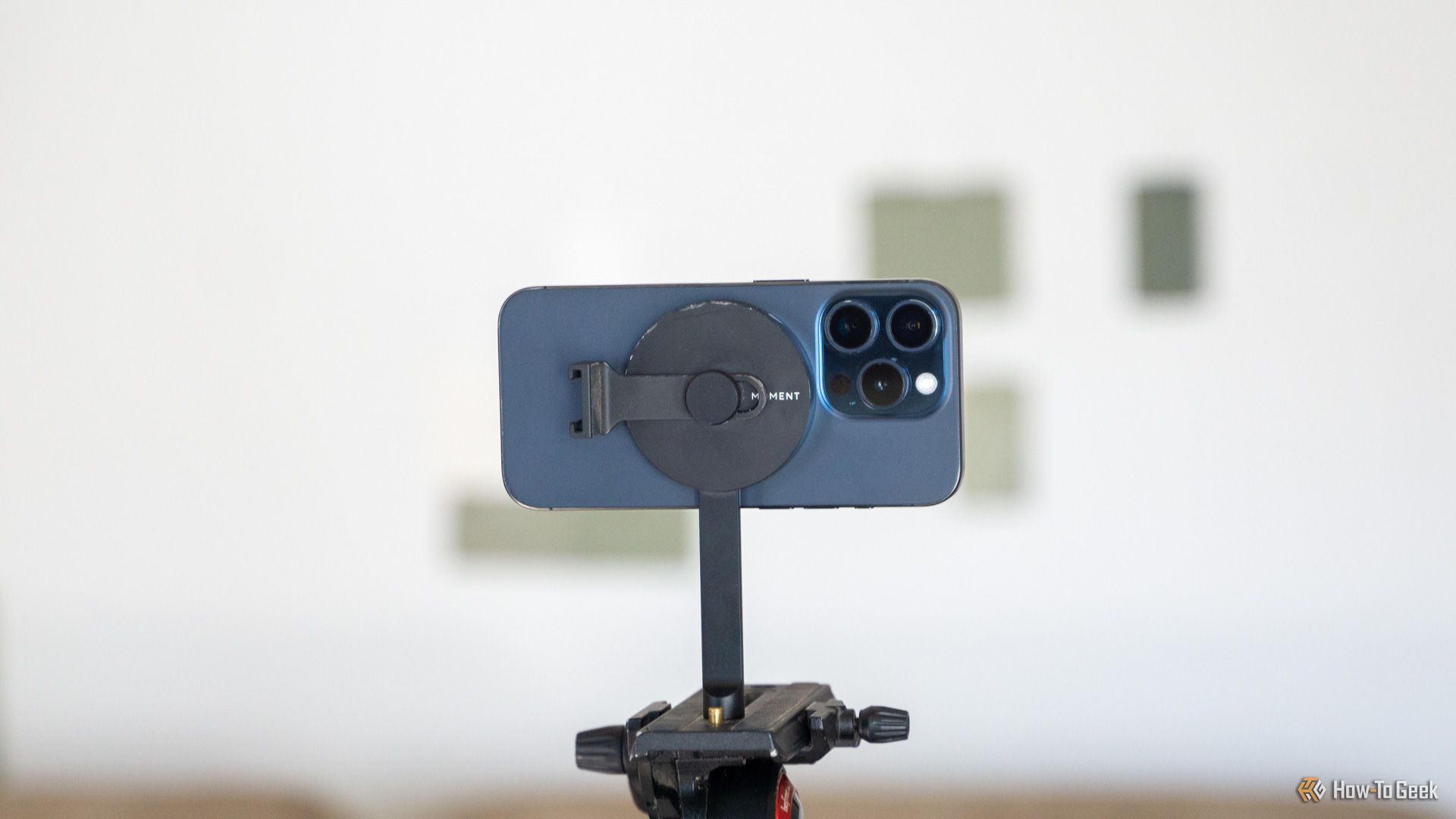 An iPhone 15 Pro mounted horizontally on the Moment MagSafe Tripod mount.