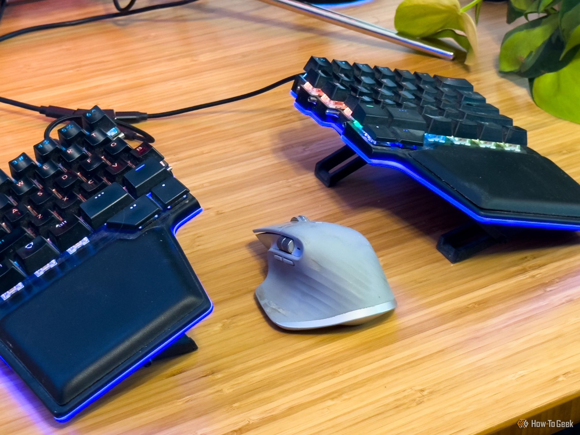 A mouse sitting between a split keyboard.