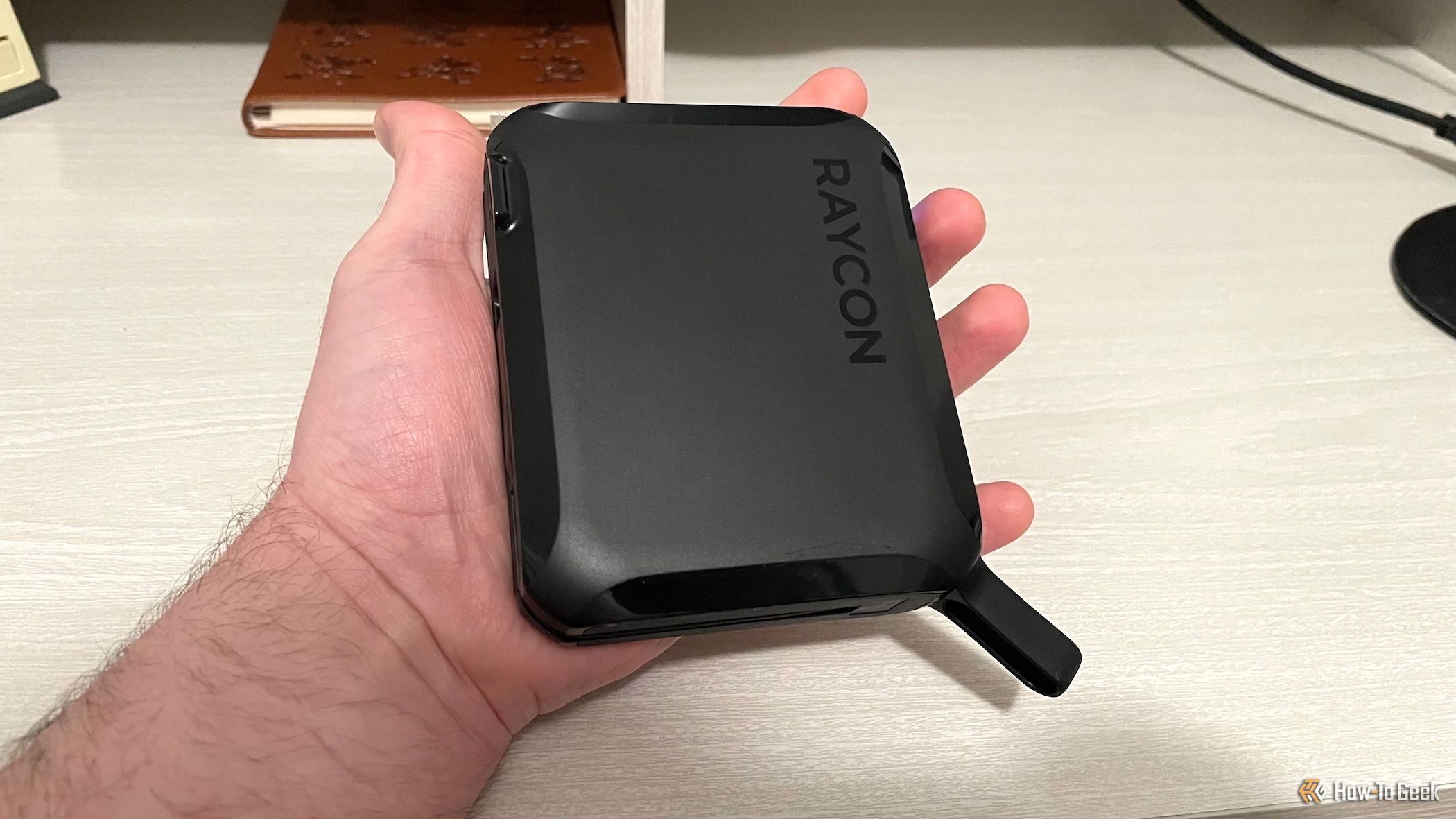 A person holding the Raycon Magic Laptop Power Bank 5-in-1.