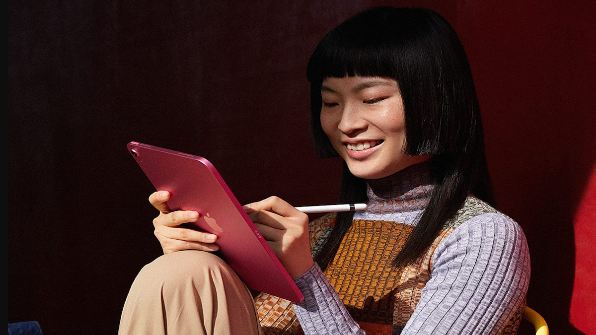 Woman using a red Apple iPad.