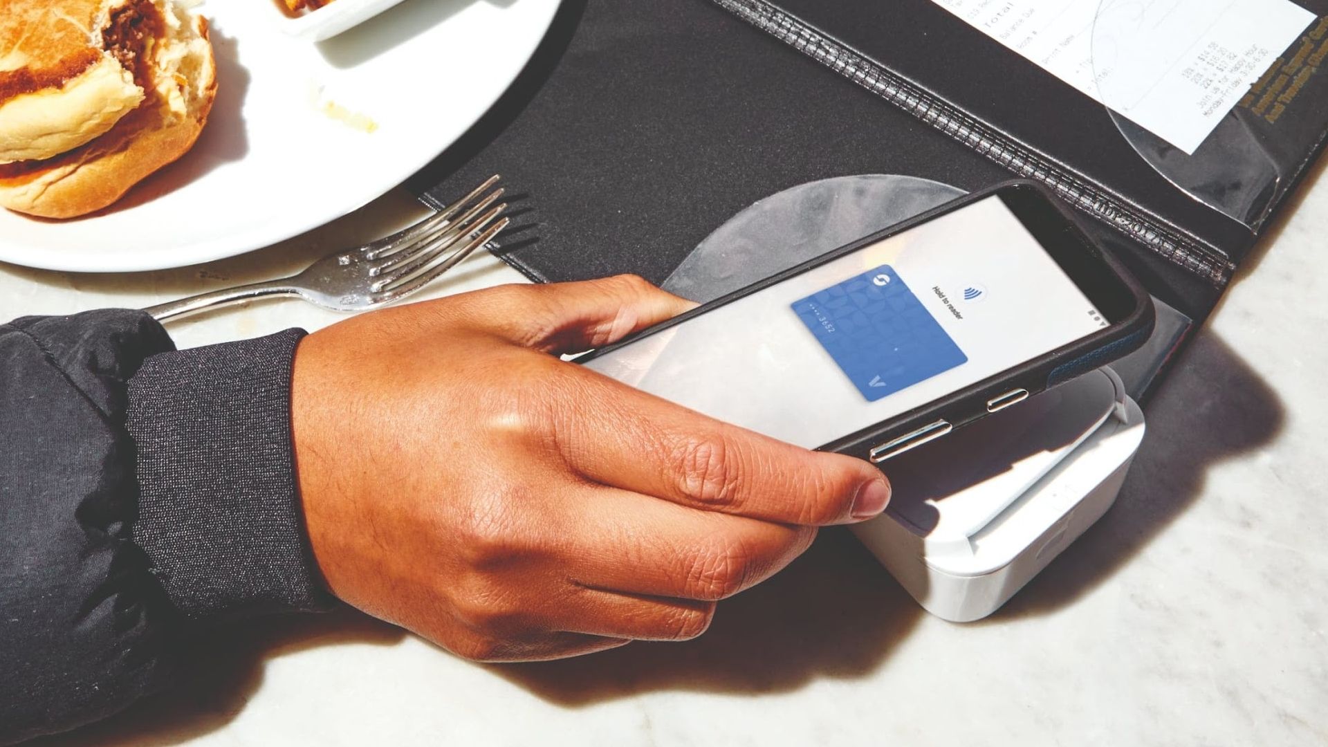 A customer paying with google wallet at a contactless terminal