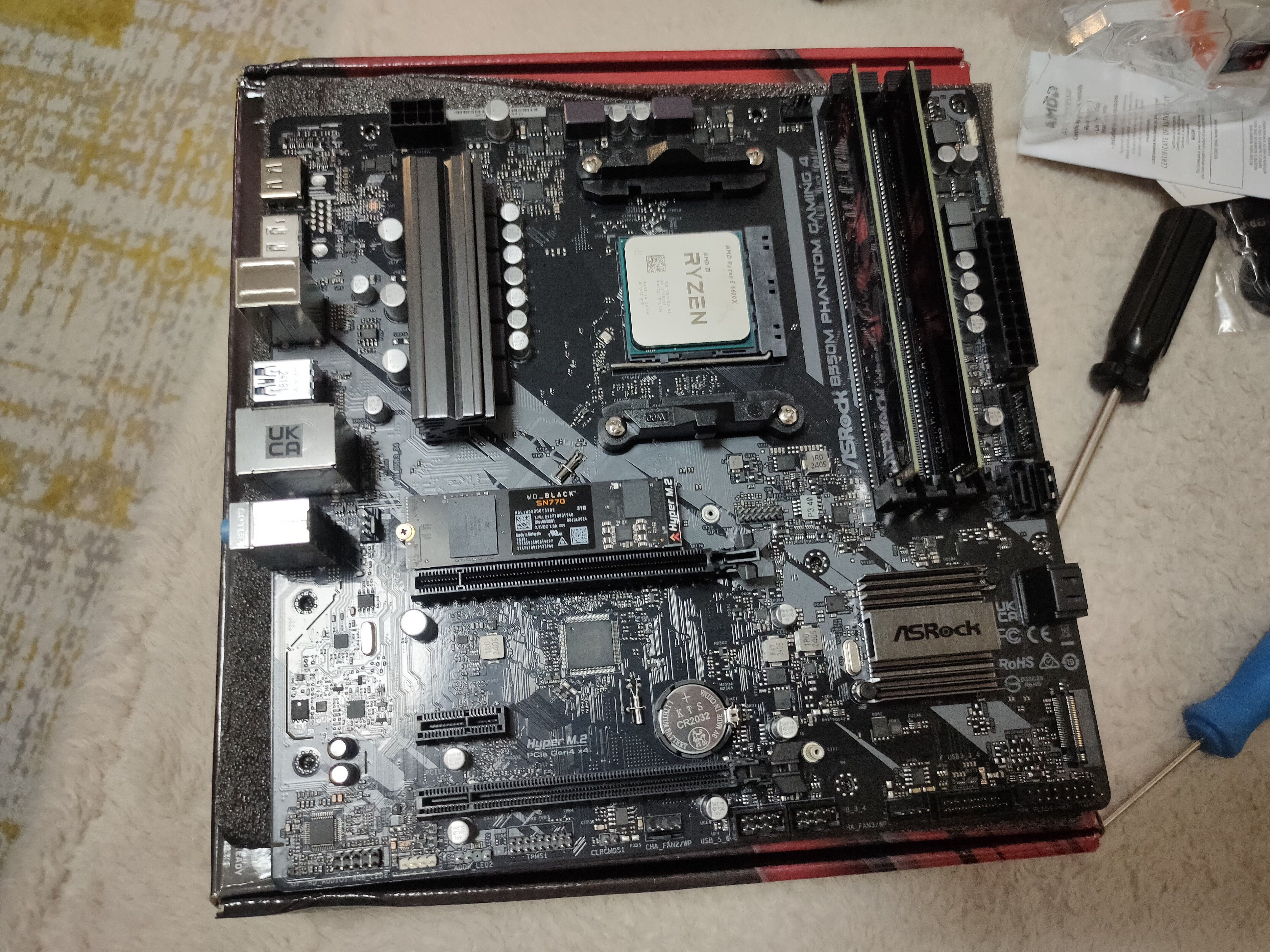 A motherboard on its box with a few components like the CPU and RAM installed.