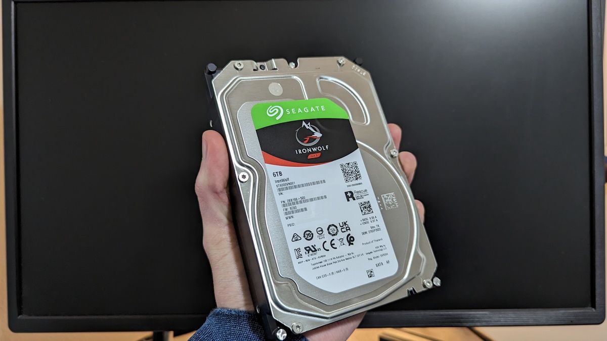 Man holding an internal hard drive in his hand.