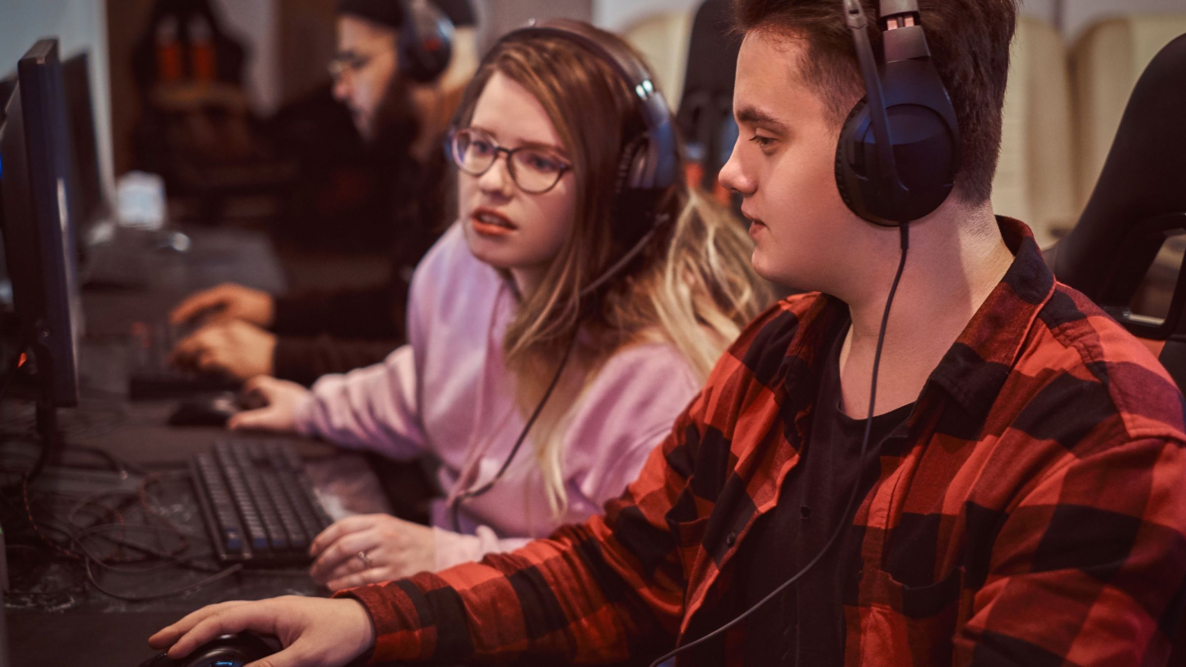 Team of teenage gamers plays in a multiplayer video game on pc in a gaming club.