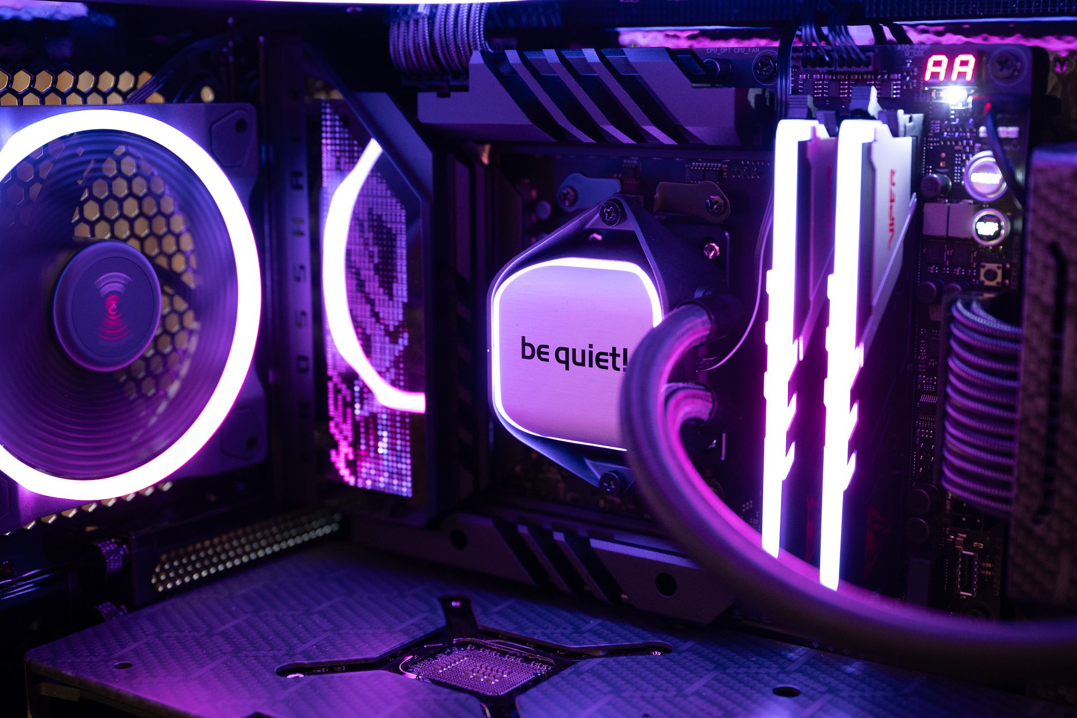 Be Quiet CPU cooler with RGB RAM and PC fan inside a gaming computer.