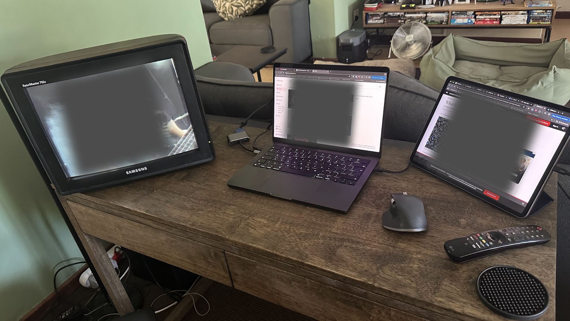 A triple monitor setup with a CRT screen a Mac and an iPad.