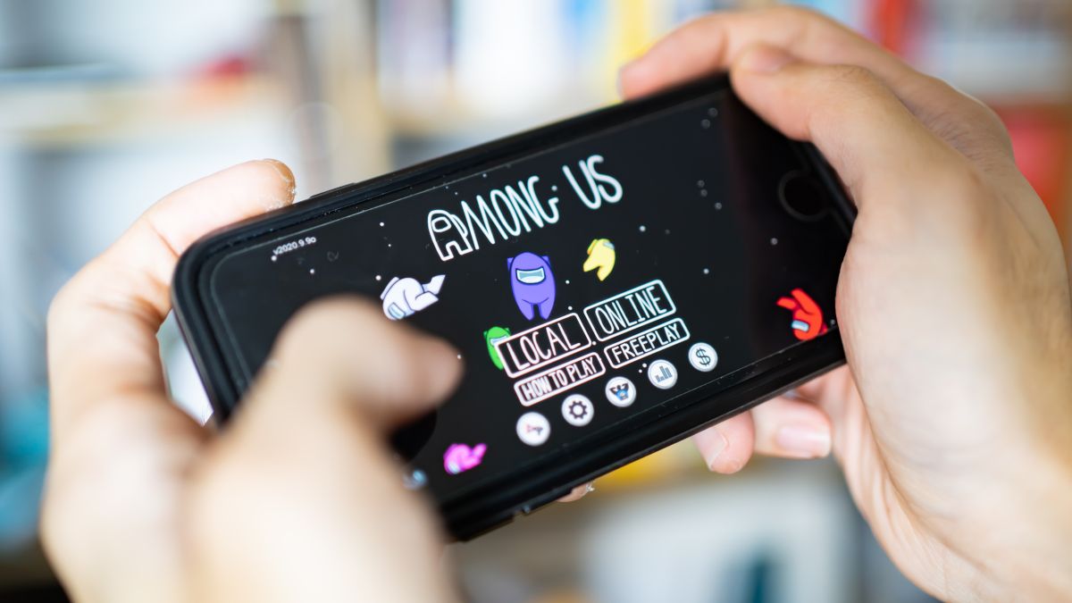 Closeup of hands playing the game "Among Us" on a smartphone