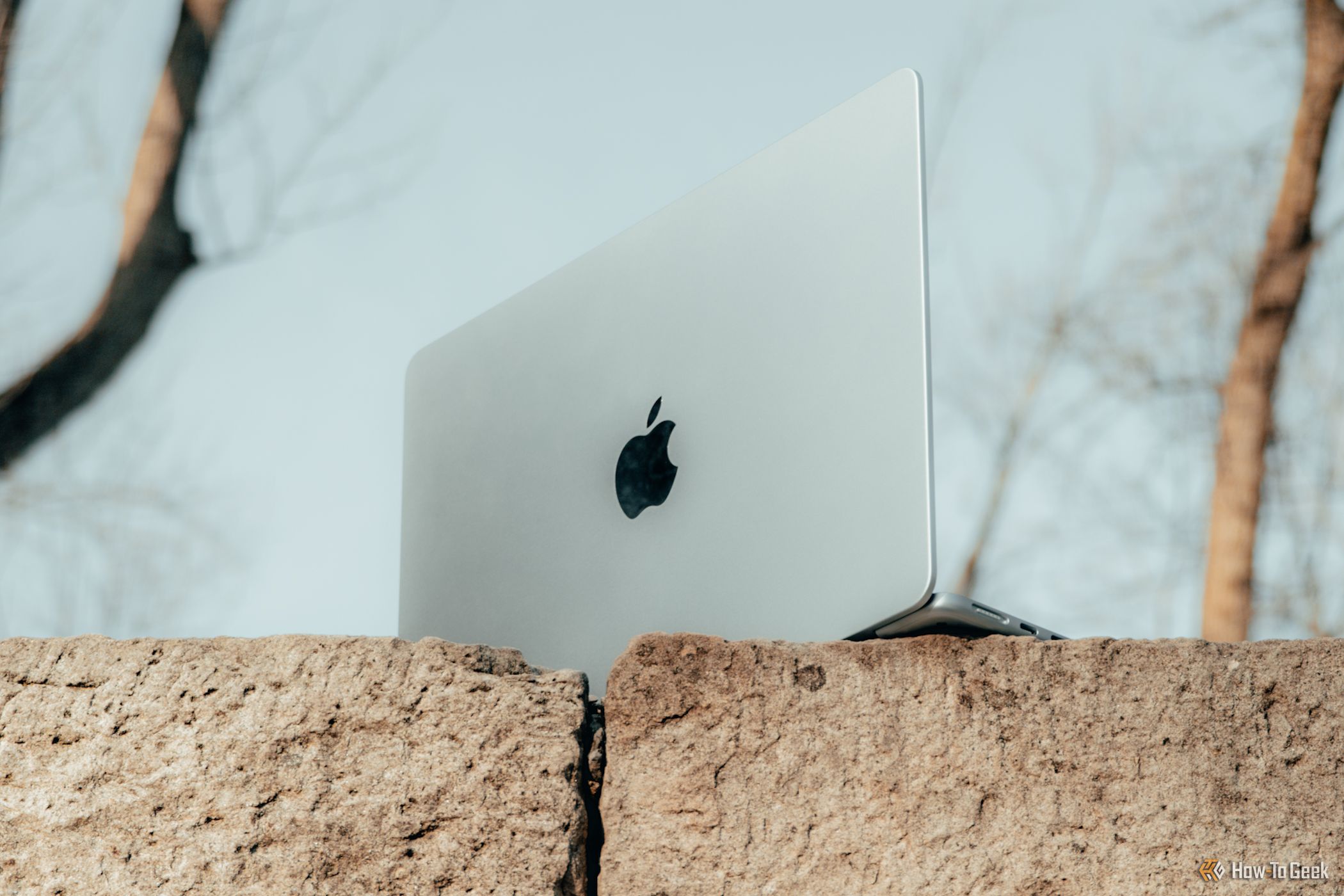 M4 MacBook Air in Sky Blue from below on bricks angled.