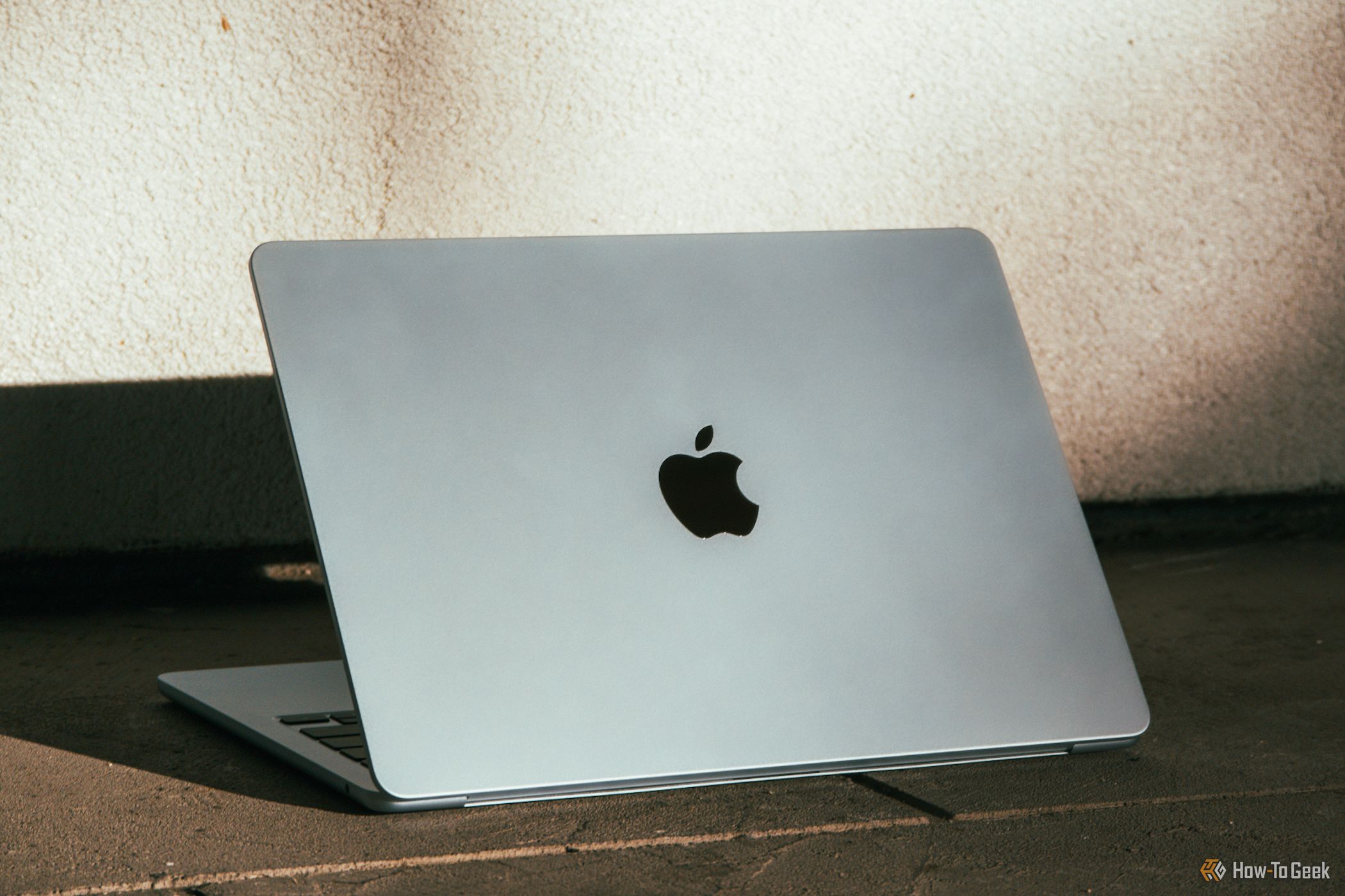 M4 MacBook Air in Sky Blue on the floor against white background.