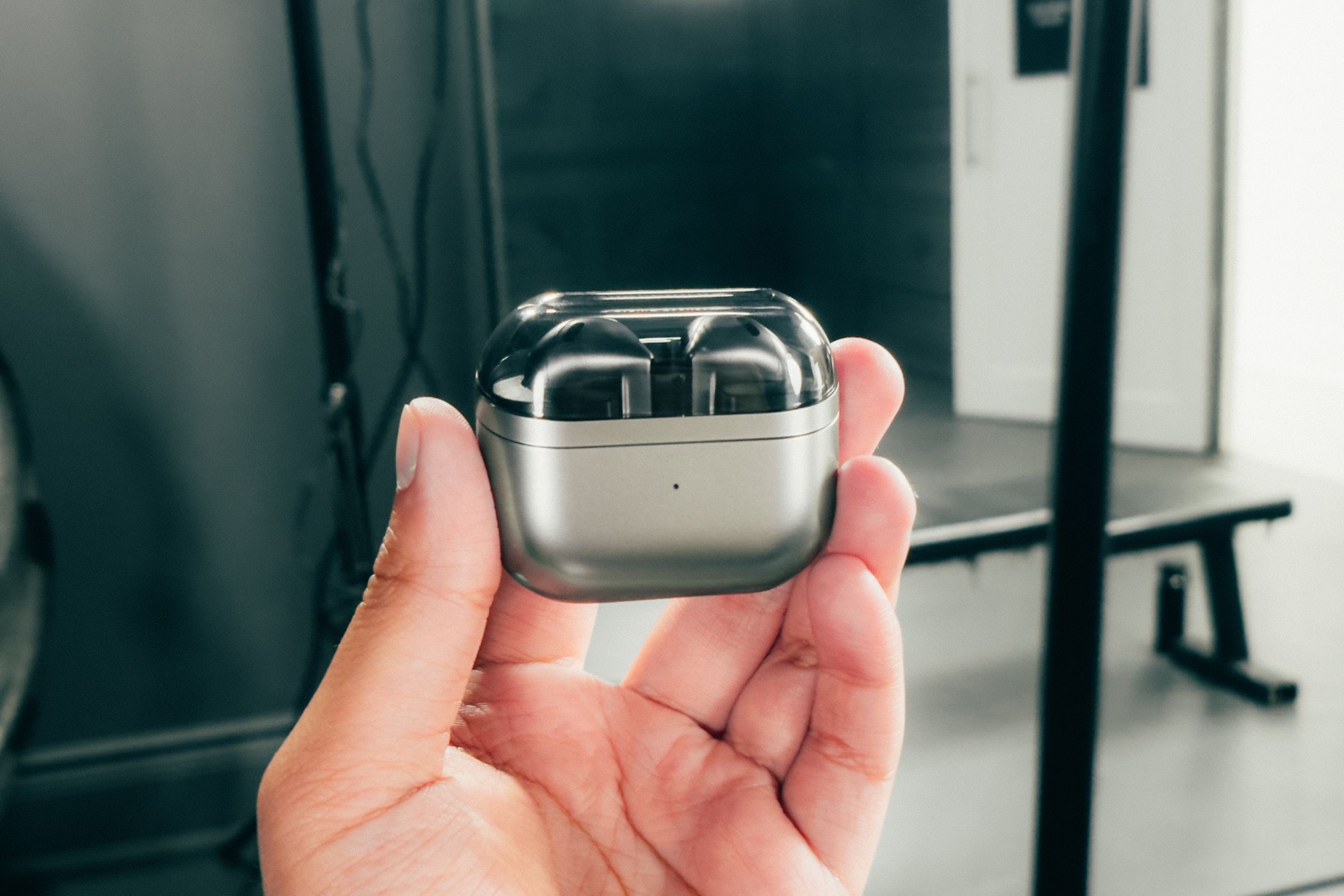 Samsung Galaxy Buds 3 inside its charging case with the lid closed held by a hand