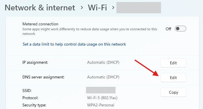 The Wifi Settings menu on Windows 11 with a red arrow pointed to the 'Edit' button for DNS server assignment.